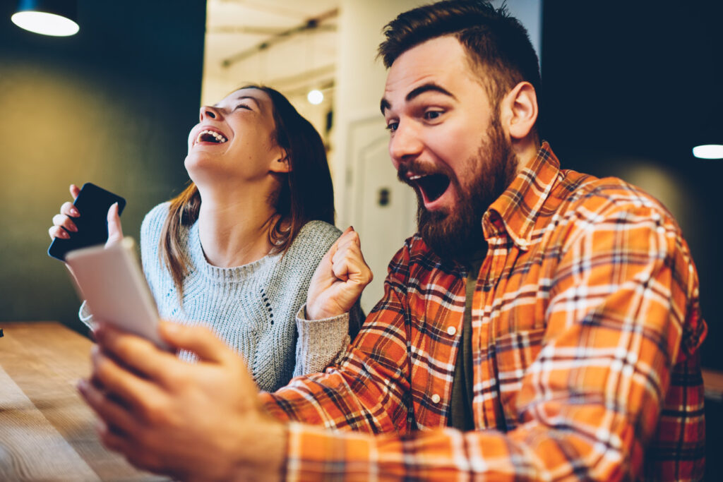 Un homme et une femme sont heureux de découvrir les cuisines èggo à prix réduit sur leur téléphone.